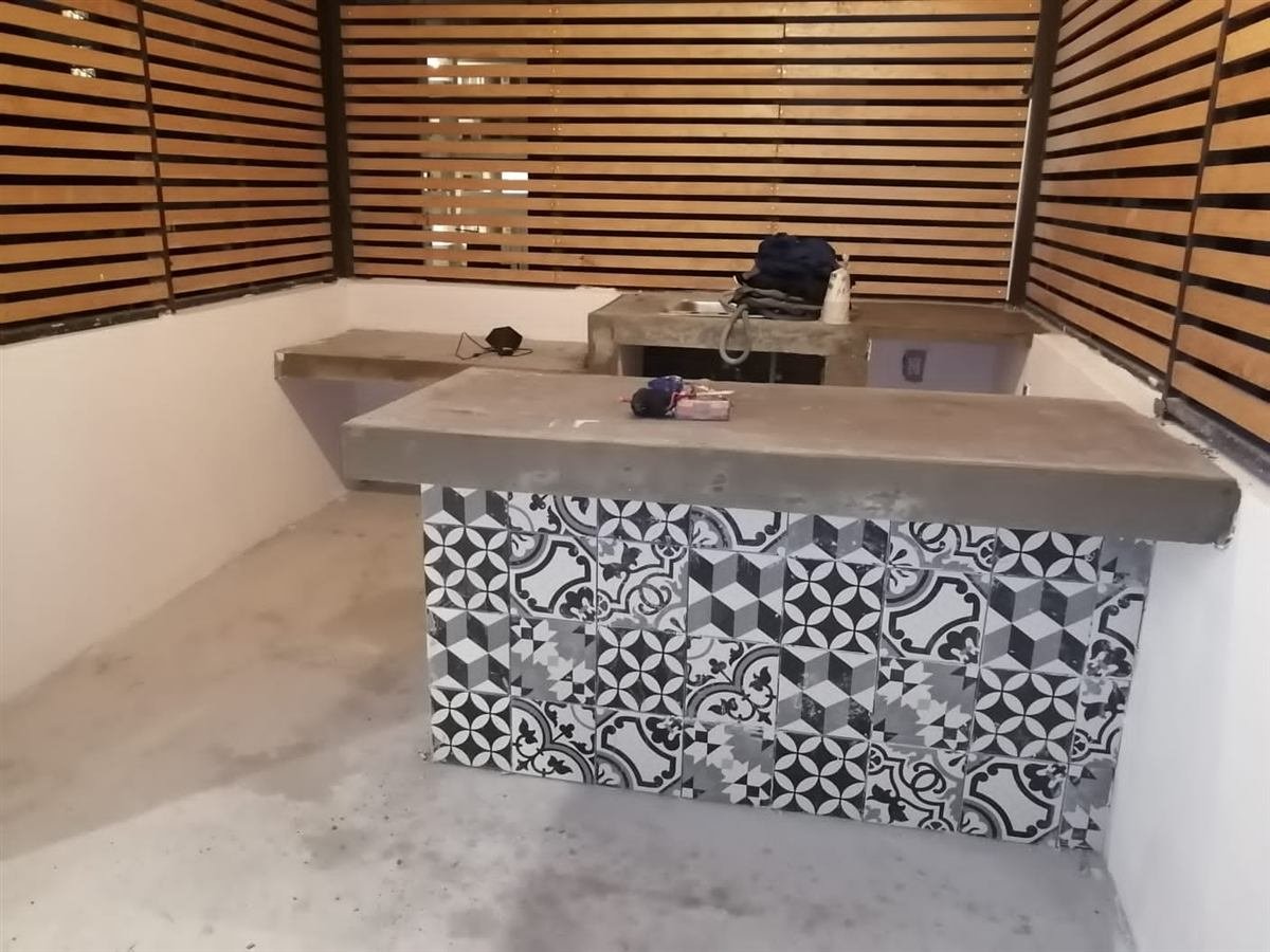 Barra exterior con celosía de madera y azulejo en proceso de obra